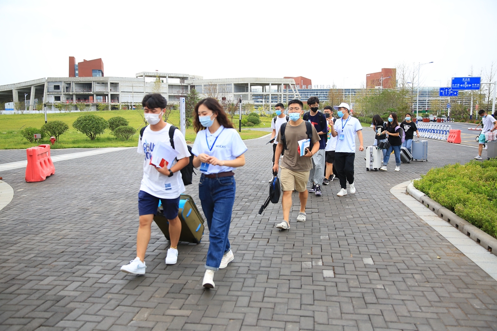 新生在志愿者引导下入住研究生公寓